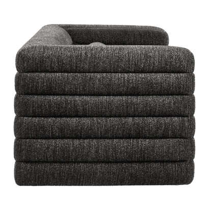 Gray channel-tufted boucle upholstered sofa with padded arms.