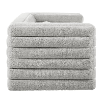 Light gray plush boucle upholstered sofa with channel tufting; modern living room seating.