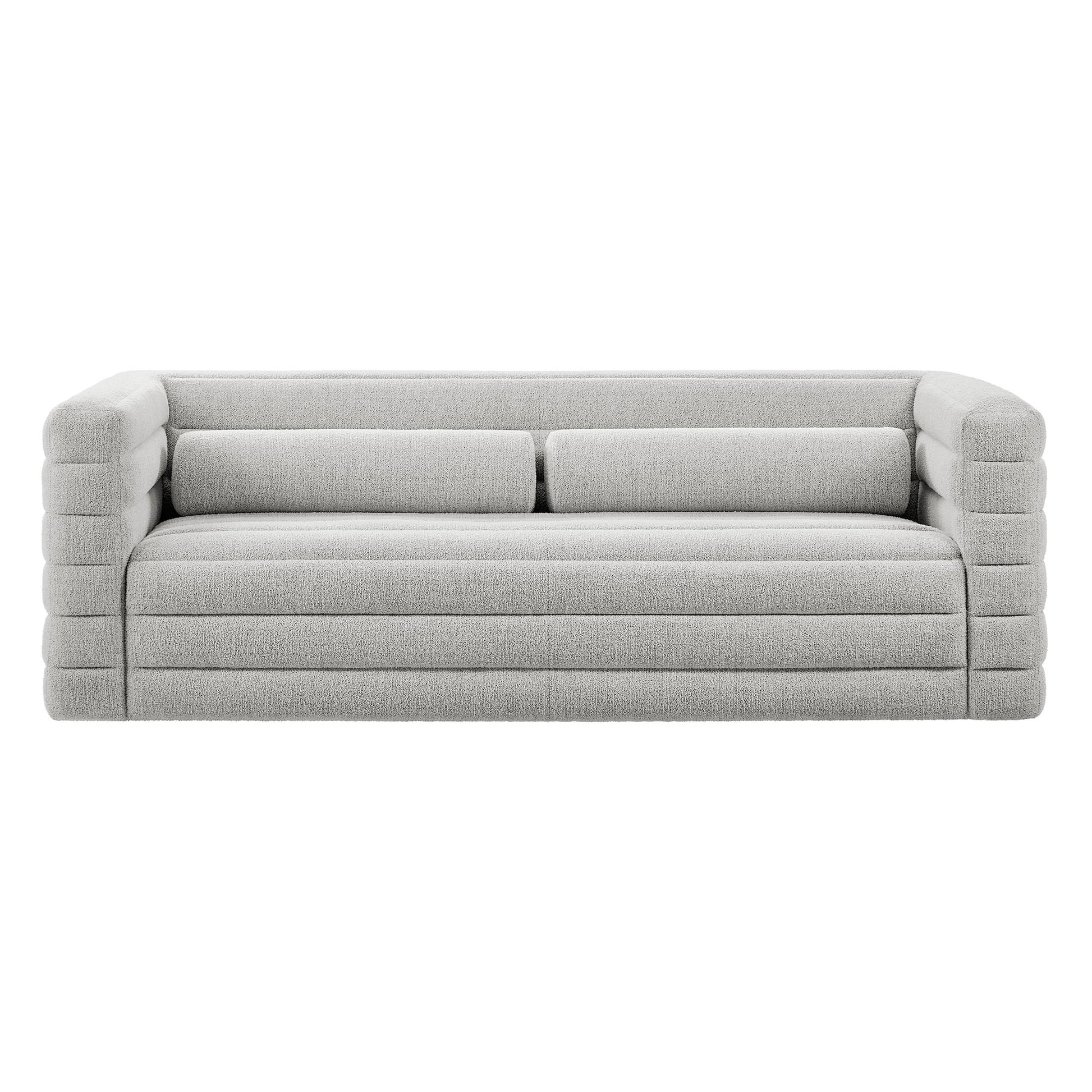 Light gray fabric sofa with chunky, segmented arms and long cushions, contemporary low-profile lounge seating.