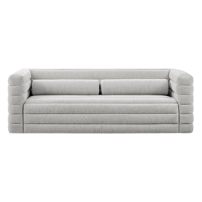 Light gray fabric sofa with chunky, segmented arms and long cushions, contemporary low-profile lounge seating.