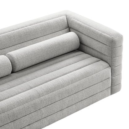Light gray textured boucle fabric modular sofa with channel-stitched cushions and cylindrical bolster pillow.
