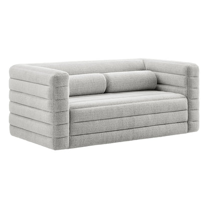 Light gray modern loveseat with chunky block arms, horizontal channel cushions, two rectangular back bolsters, boucle upholstery.