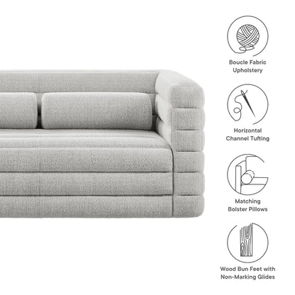 Light gray boucle fabric loveseat with horizontal channel tufting, matching bolster pillows, and wood bun feet.