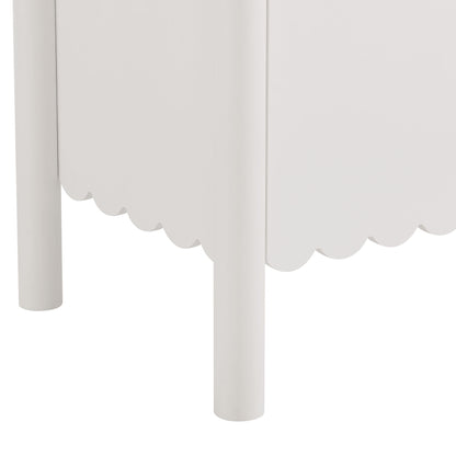 White wooden sideboard cabinet with cylindrical legs and scalloped bottom trim.