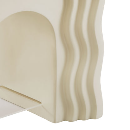 Ivory side table with a rounded arch silhouette and vertical wavy ridges along the edge.