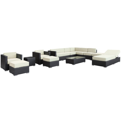 Outdoor dark wicker sectional with cream cushions; modular set includes sofa, chairs, ottomans and glass-top coffee table.