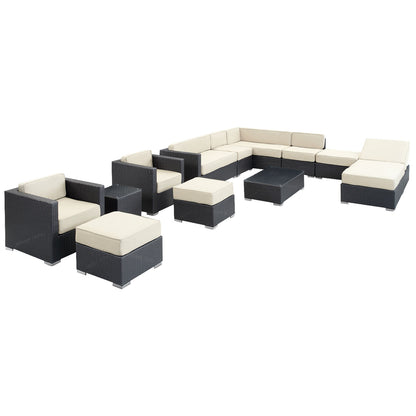 Dark wicker outdoor sectional with cream cushions; modular set includes corner, armless units and ottomans for seating.