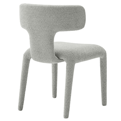 Grey boucle upholstered dining chair with curved back and four tapered legs.