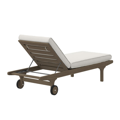 Teak outdoor patio chaise lounge chair with white cushions, adjustable back, wheeled base, slatted frame.