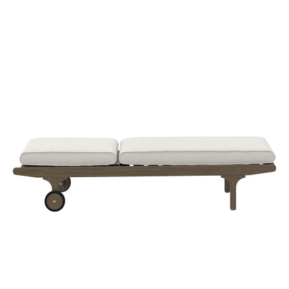 Teak outdoor chaise lounge with two white cushions, long low daybed on wheels.