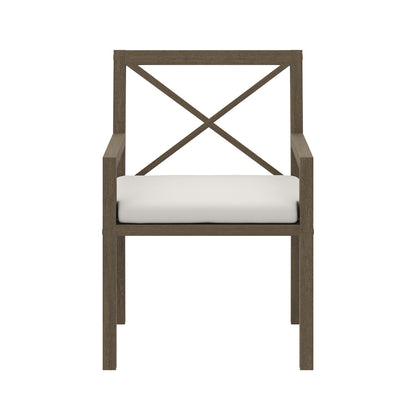 Teak outdoor dining armchair with a crisscross back and white cushion.