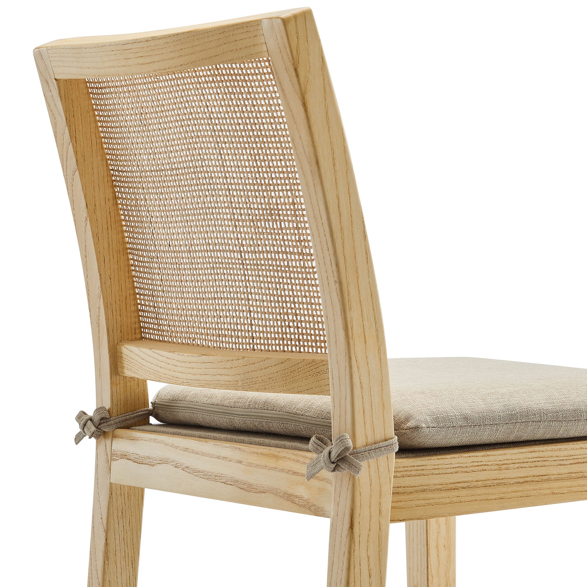 Natural wood and rattan counter stool with a caned back and beige upholstered seat cushion.