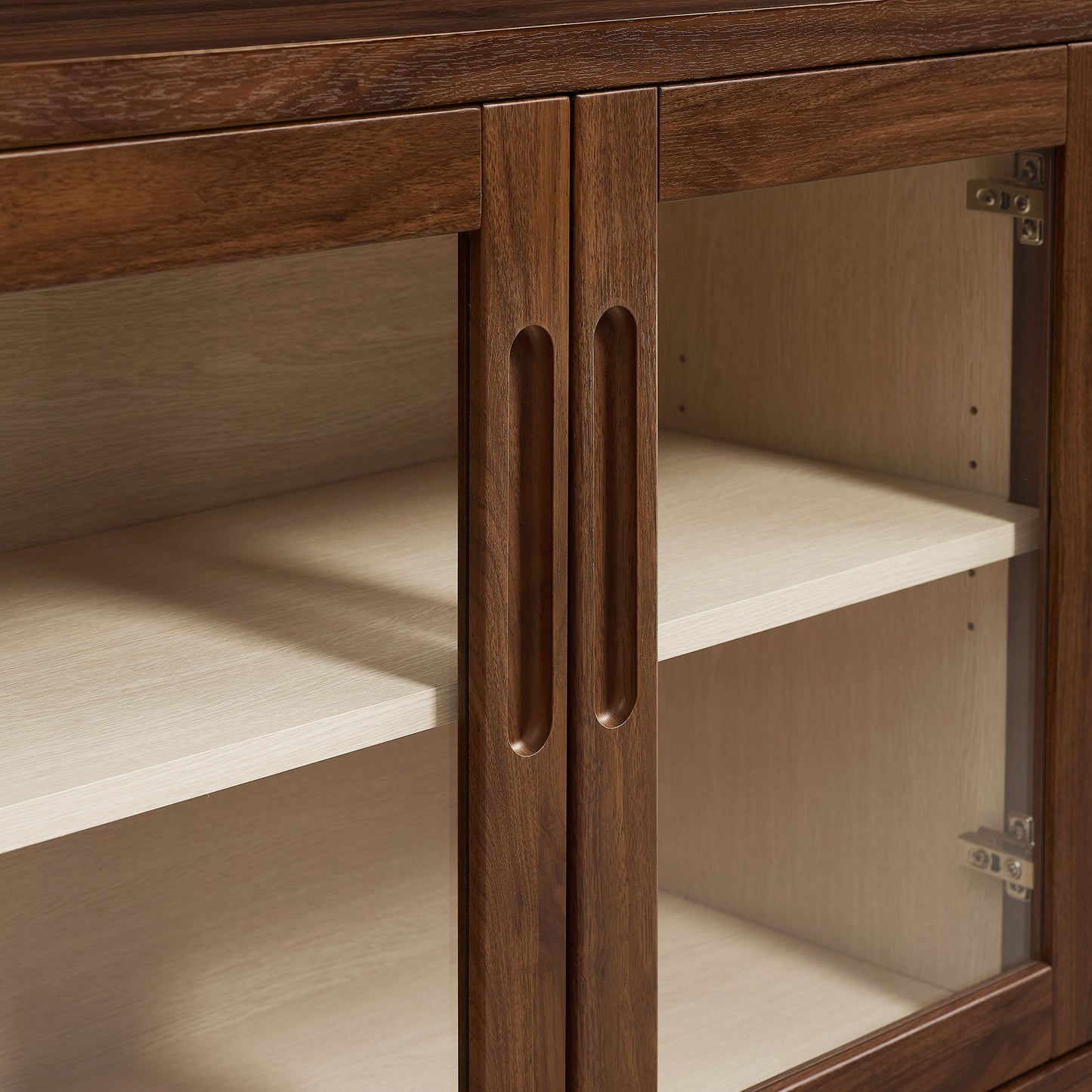 Walnut wood cabinet with glass doors, vertical pull handles, light ash interior shelves.