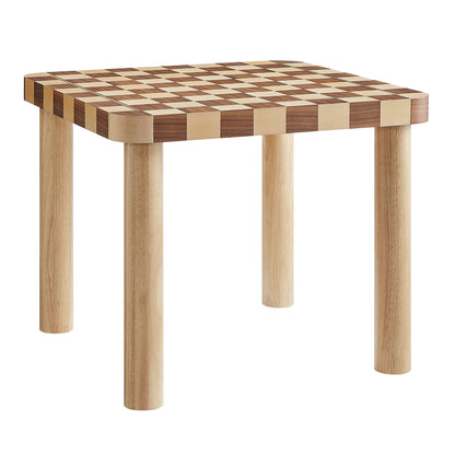 Square wooden dining table with a checkerboard top in light and dark wood and four natural legs.