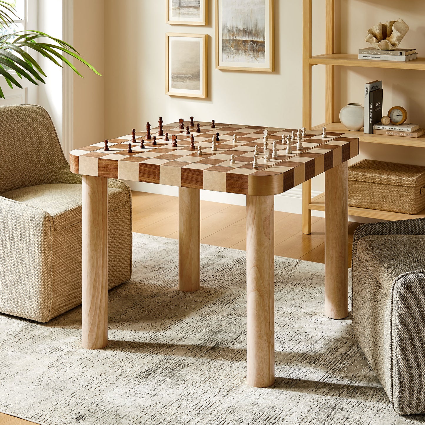 Square checkered dining table with light and dark oak and walnut wood squares and chunky rounded legs in a warm living room.