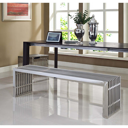 Two silver metal benches with slatted vertical sides and rectangular frames, in front of a dark wood console.