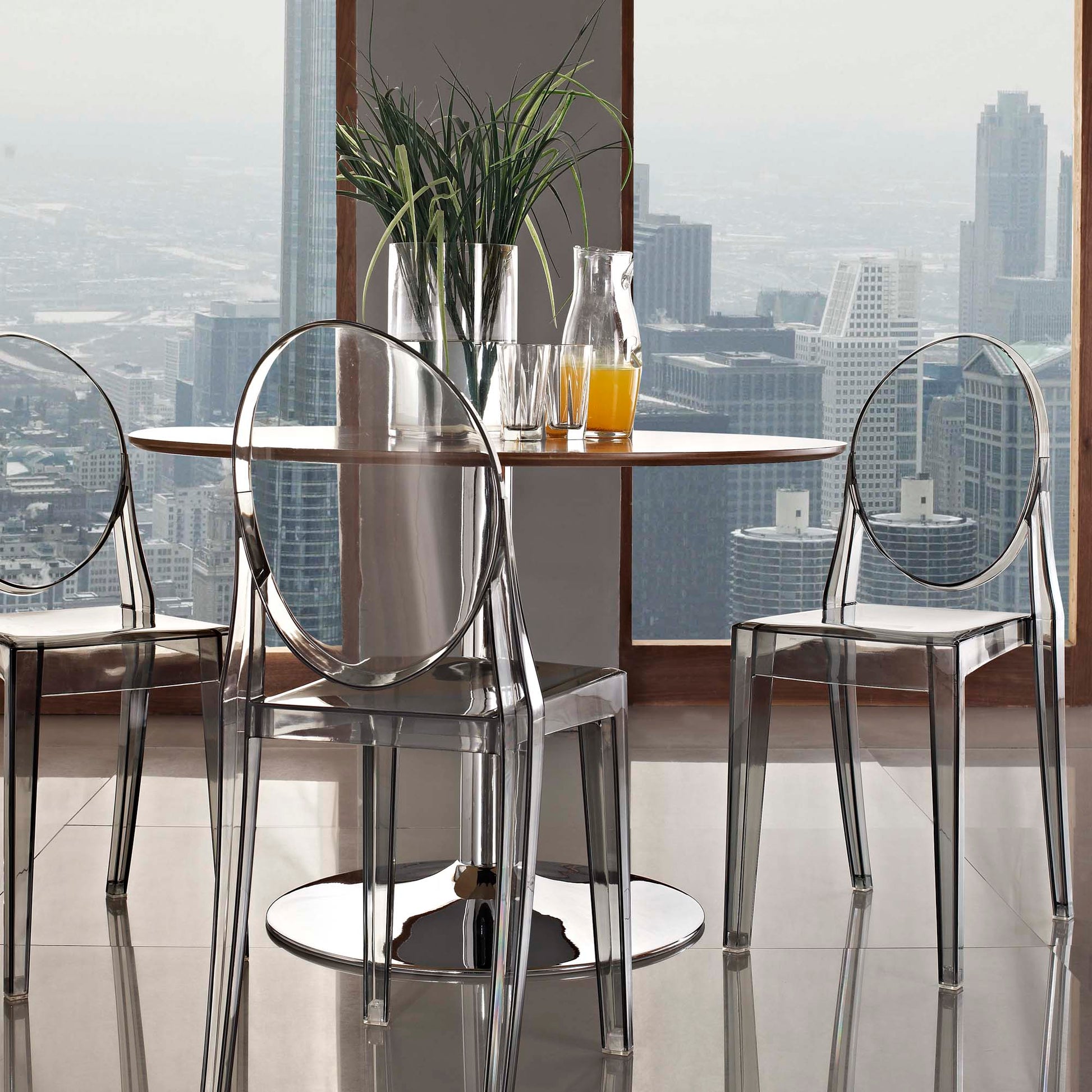 Clear acrylic dining chairs with circular backs, set of 2; urban skyline backdrop.