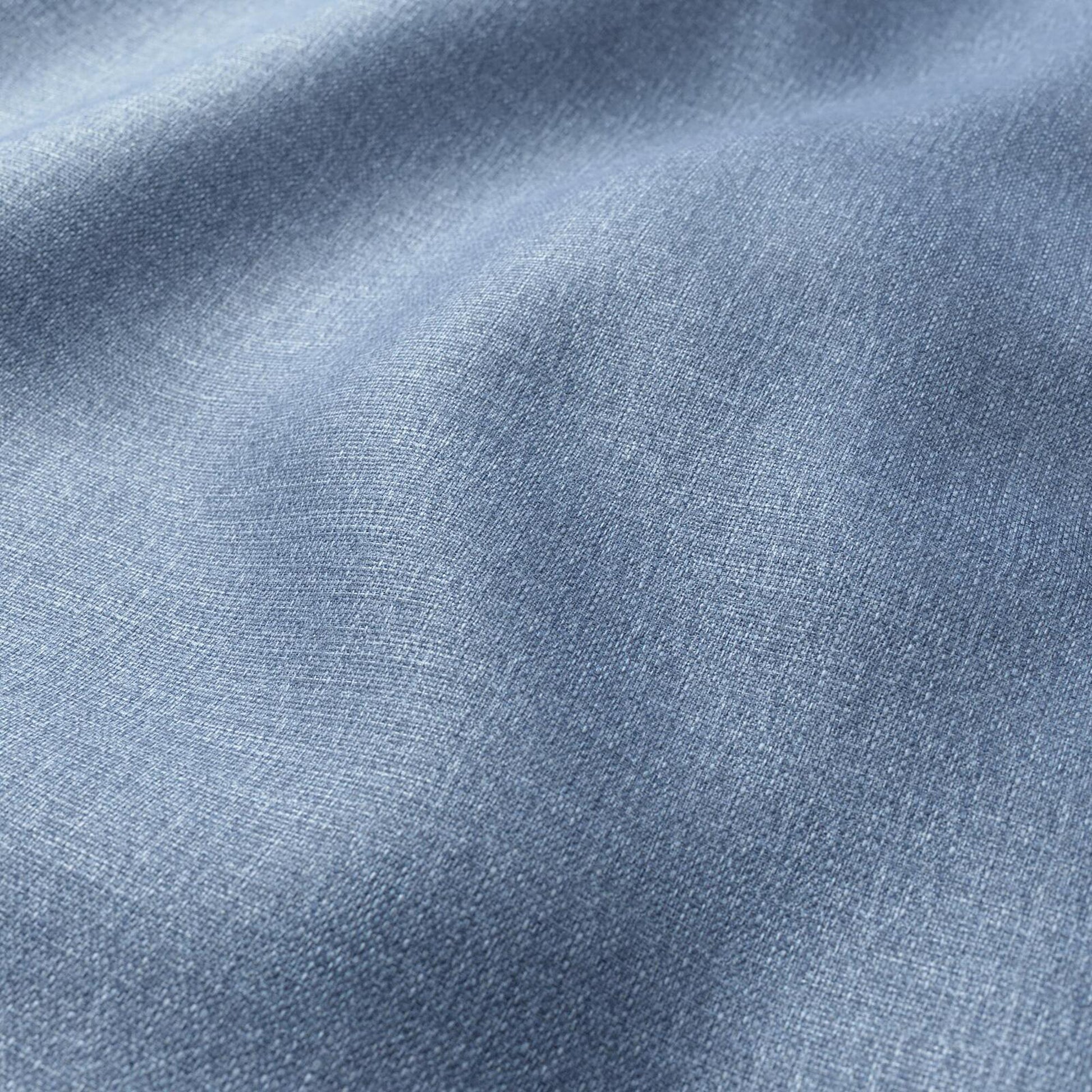 Close-up of light blue denim fabric, showing textured weave and soft folds.