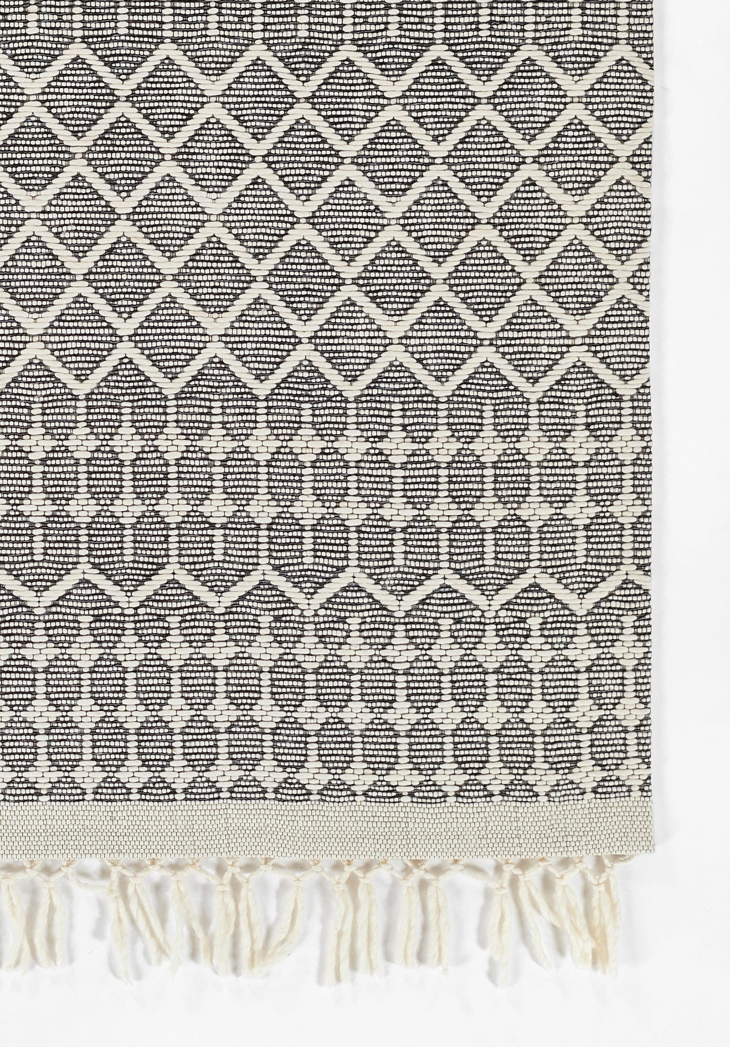 Rectangular black-and-cream cotton woven rug with diamond lattice pattern and fringe tassels, 2' x 3'.