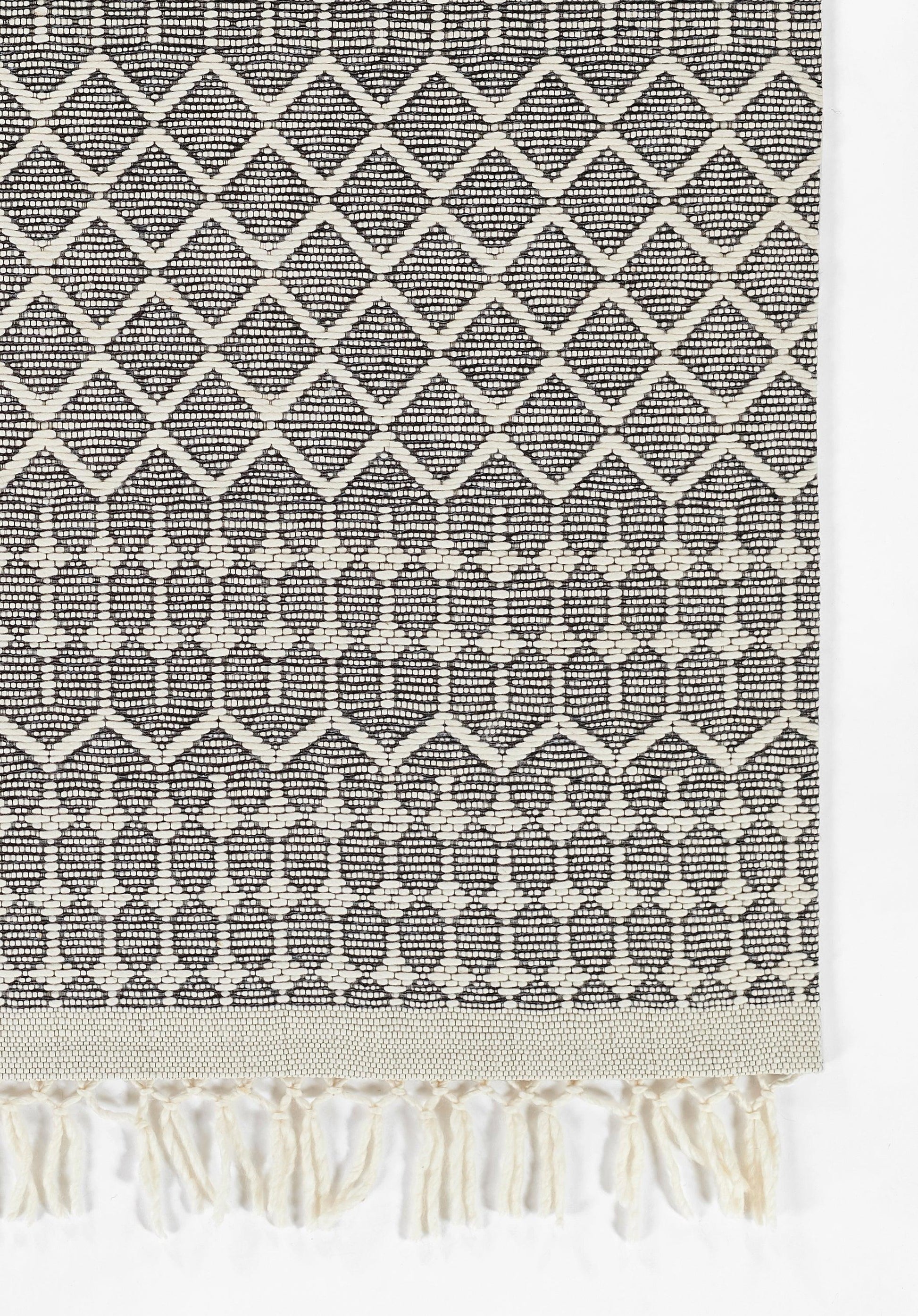 Rectangular black-and-cream cotton woven rug with diamond lattice pattern and fringe tassels, 2' x 3'.
