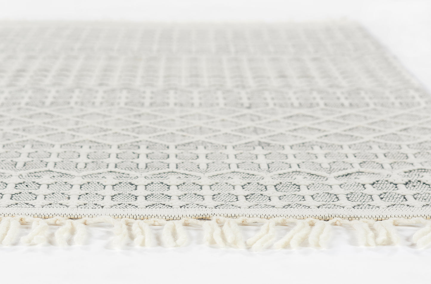 Light gray lace rug, 2' x 3', with geometric diamond pattern and cream fringe