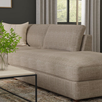Mushroom solid fabric sectional sofa with chaise in a modern living room setting, featuring a wood-top coffee table and a green plant.