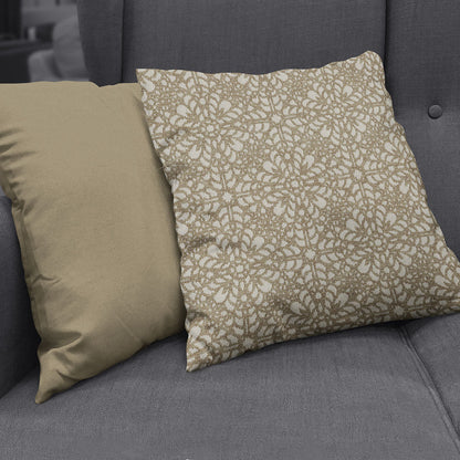 Two decorative throw pillows on a dark grey sofa; solid beige pillow beside a beige-and-white floral patterned cushion.