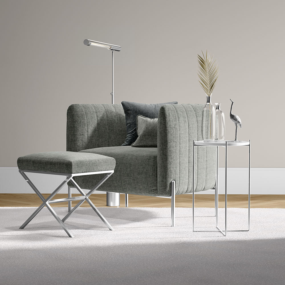Grey fabric modular sofa with matching ottoman, chrome legs, glass side tables and a floor lamp in a modern living room.