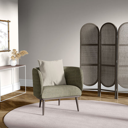 Olive green solid textured fabric swatch; room scene shows a cream-cushioned chair on a round pink rug, white console with dried grasses, and a woven folding screen backdrop.