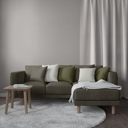 Endur Loft modular sofa with chaise in olive-brown, mixed green/gray cushions, wood coffee table, light gray rug and curtains.