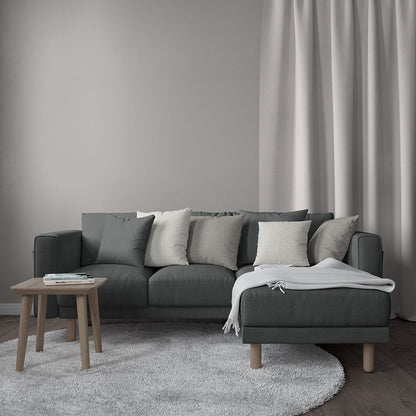 Charcoal fabric sectional with light gray cushions, chaise and throw, metal legs, beige shag rug, small wood coffee table.