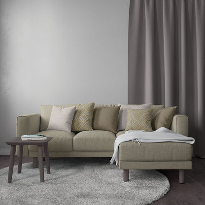 Beige fabric sofa with chaise, multiple neutral cushions, dark wood round side table, light gray rug, and gray curtains.