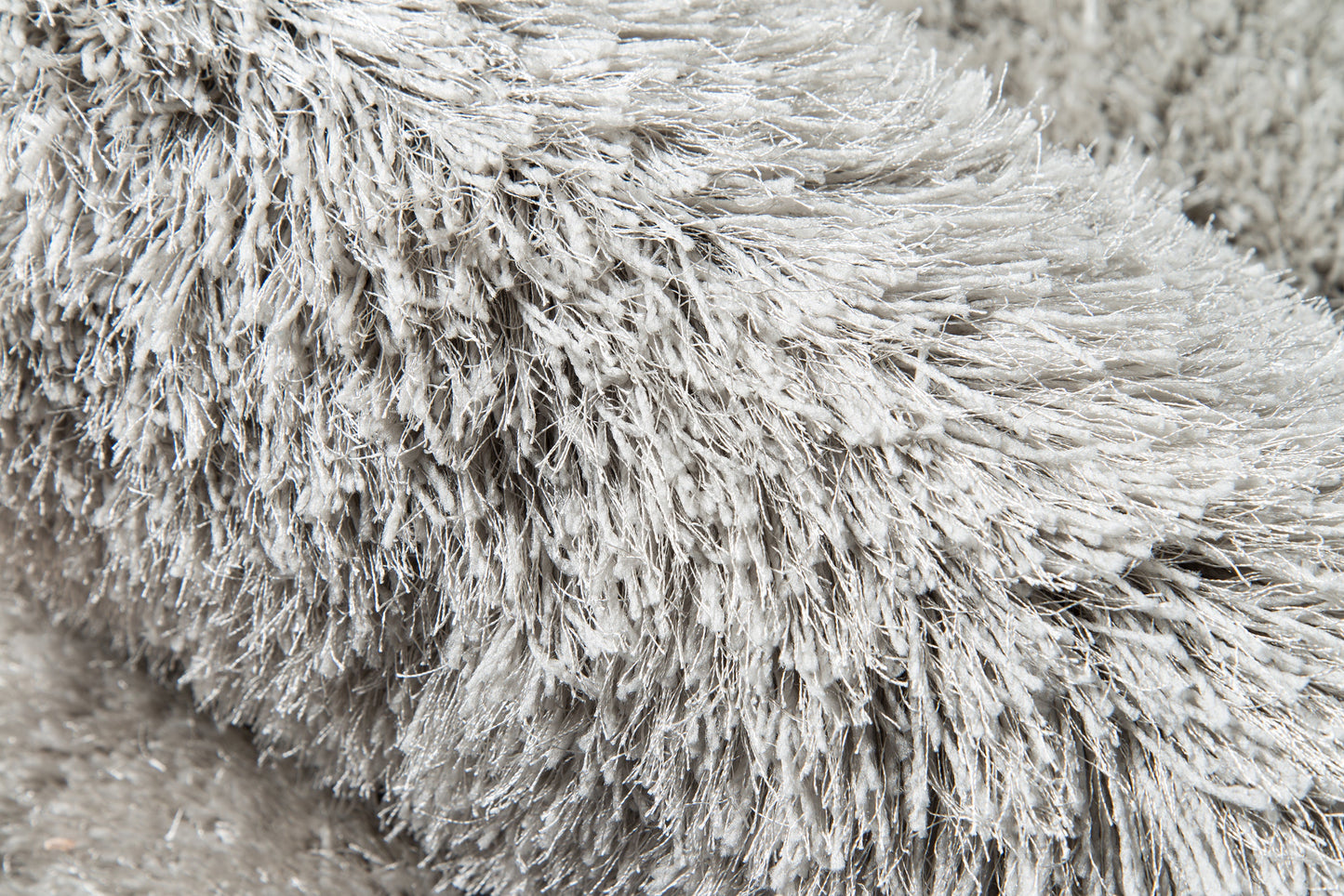 Grey shag rug close-up with ultra-plush long-pile fur for cozy, modern home decor.