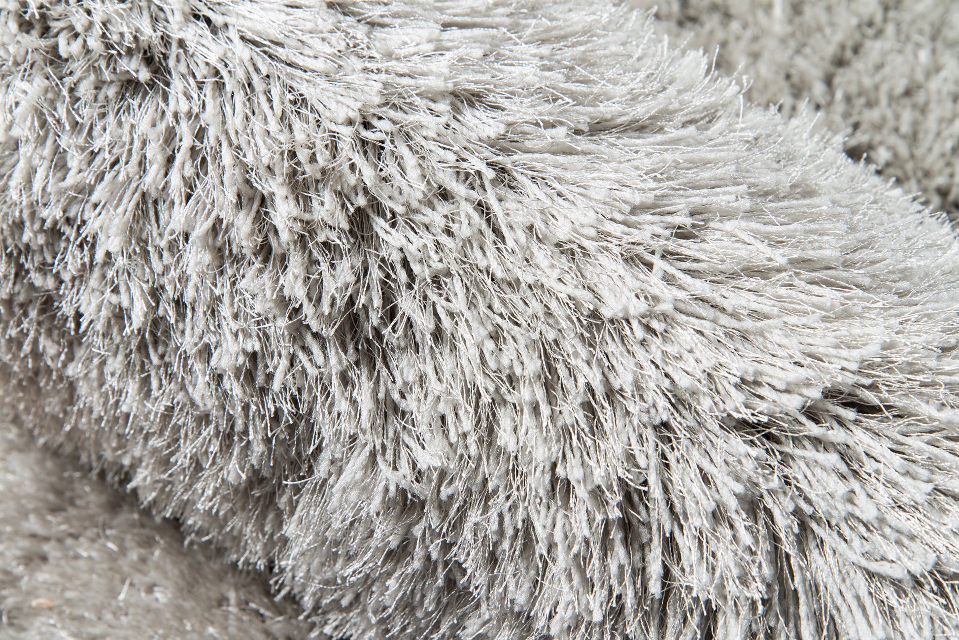 Grey shag rug close-up with ultra-plush long-pile fur for cozy, modern home decor.