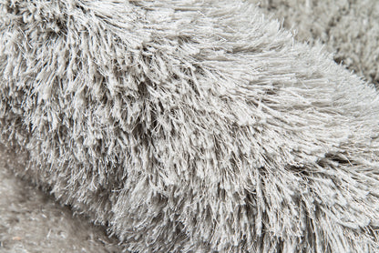 Grey shag rug close-up with ultra-plush long-pile fur for cozy, modern home decor.