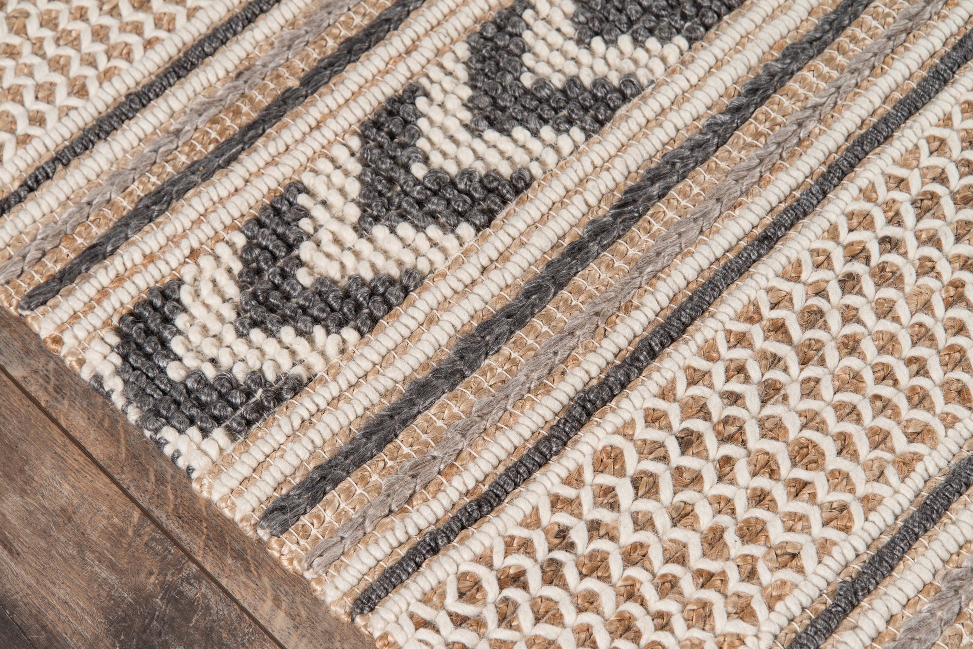 Handwoven natural jute rug, 2' x 3', cream, beige and black geometric chevron stripes on a wooden floor.