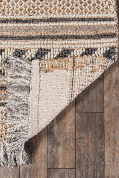 Handwoven neutral-toned rug with fringed ends, striped beige, cream, gray and brown geometric pattern on wooden floor.