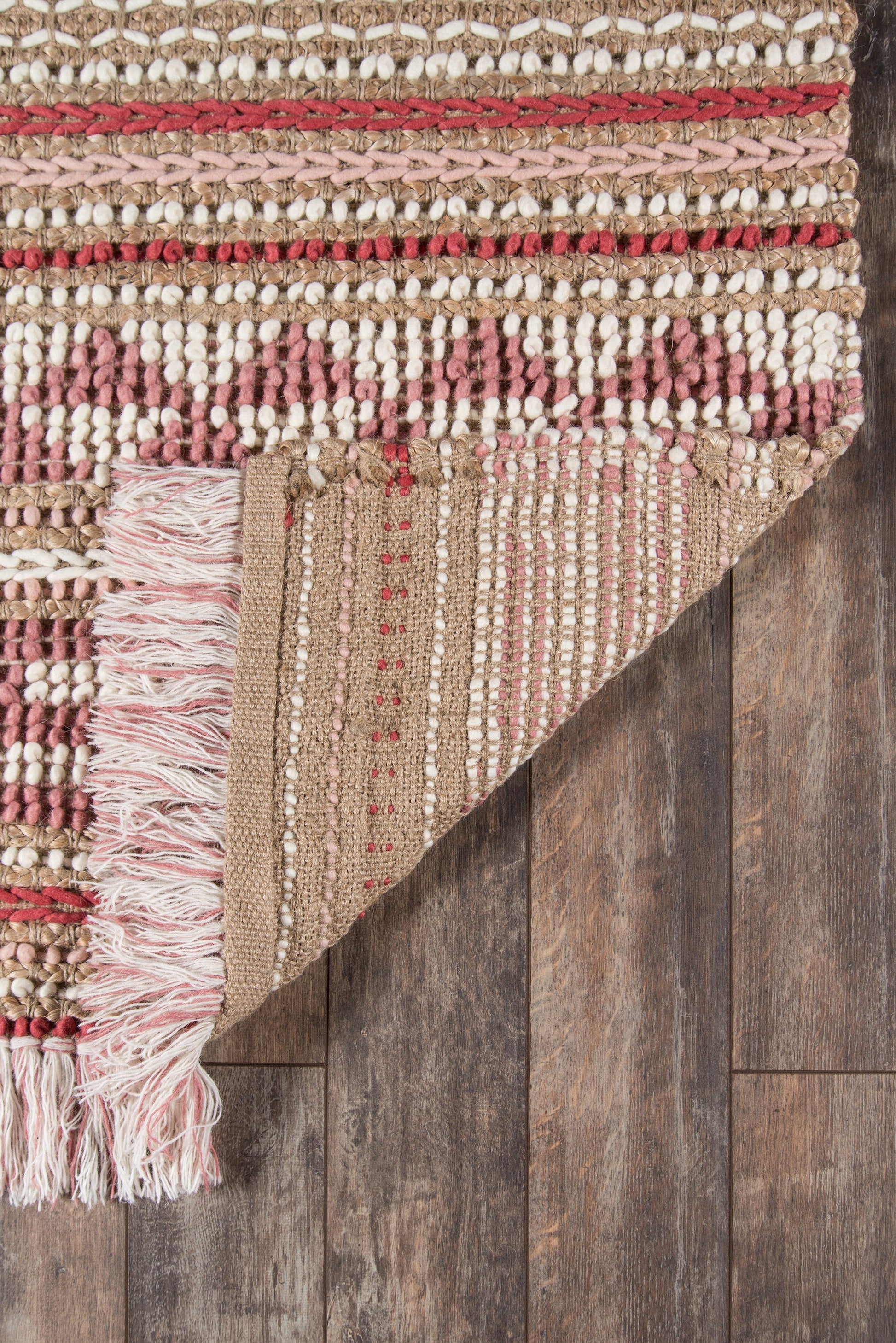 Beige-tan woven runner rug (2' x 8') with pink-red stripes and fringe on a dark wood floor.