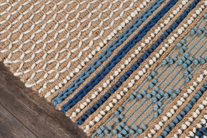 Close-up of beige jute rug with blue braided stripes on dark wood floor.