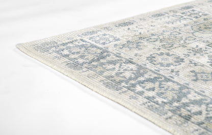 Light ivory and gray oriental rug with distressed blue-gray floral motifs; corner view.