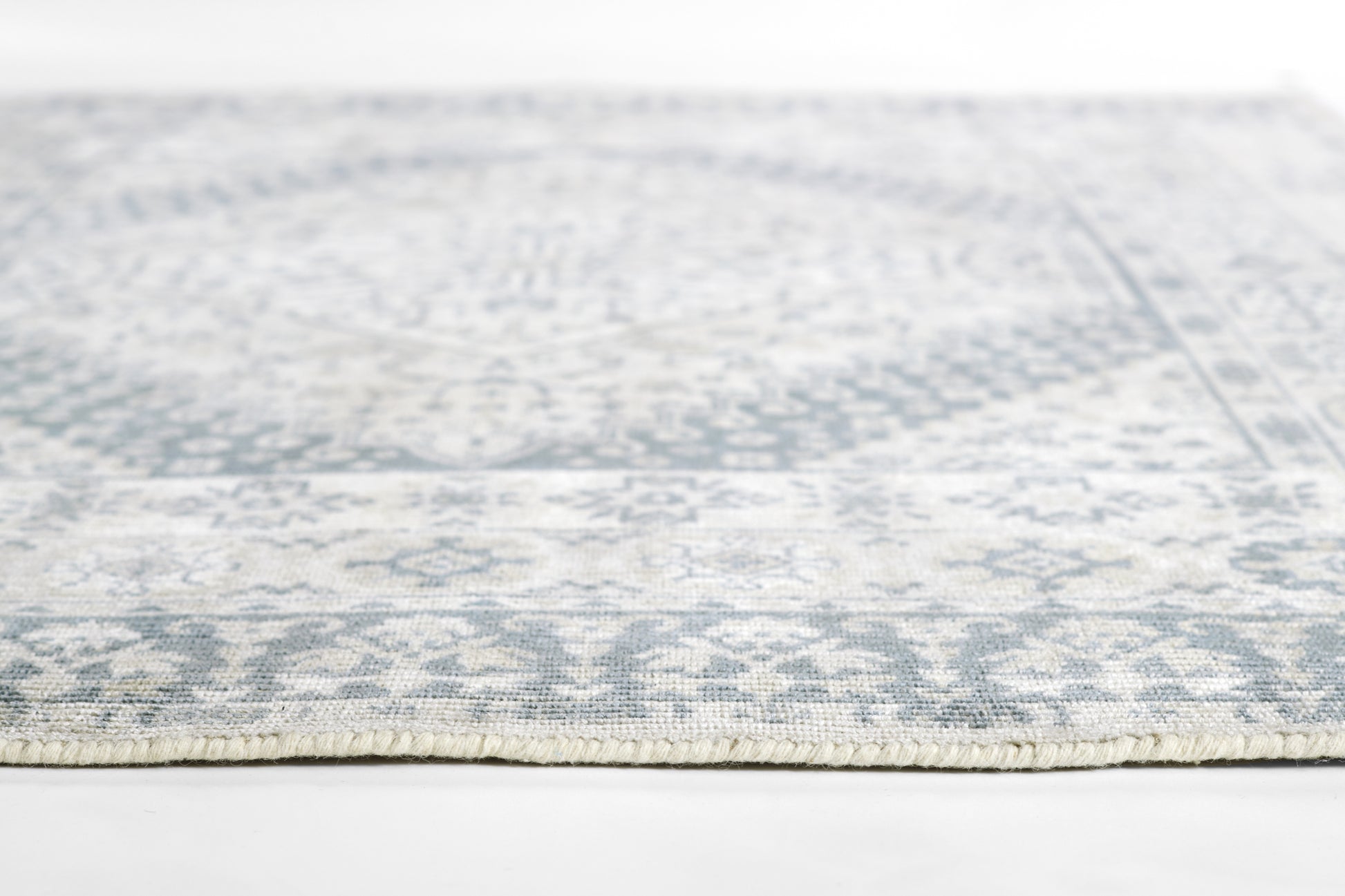 Gray & ivory rectangular area rug with geometric pattern and fringed edge, 2' x 3'.