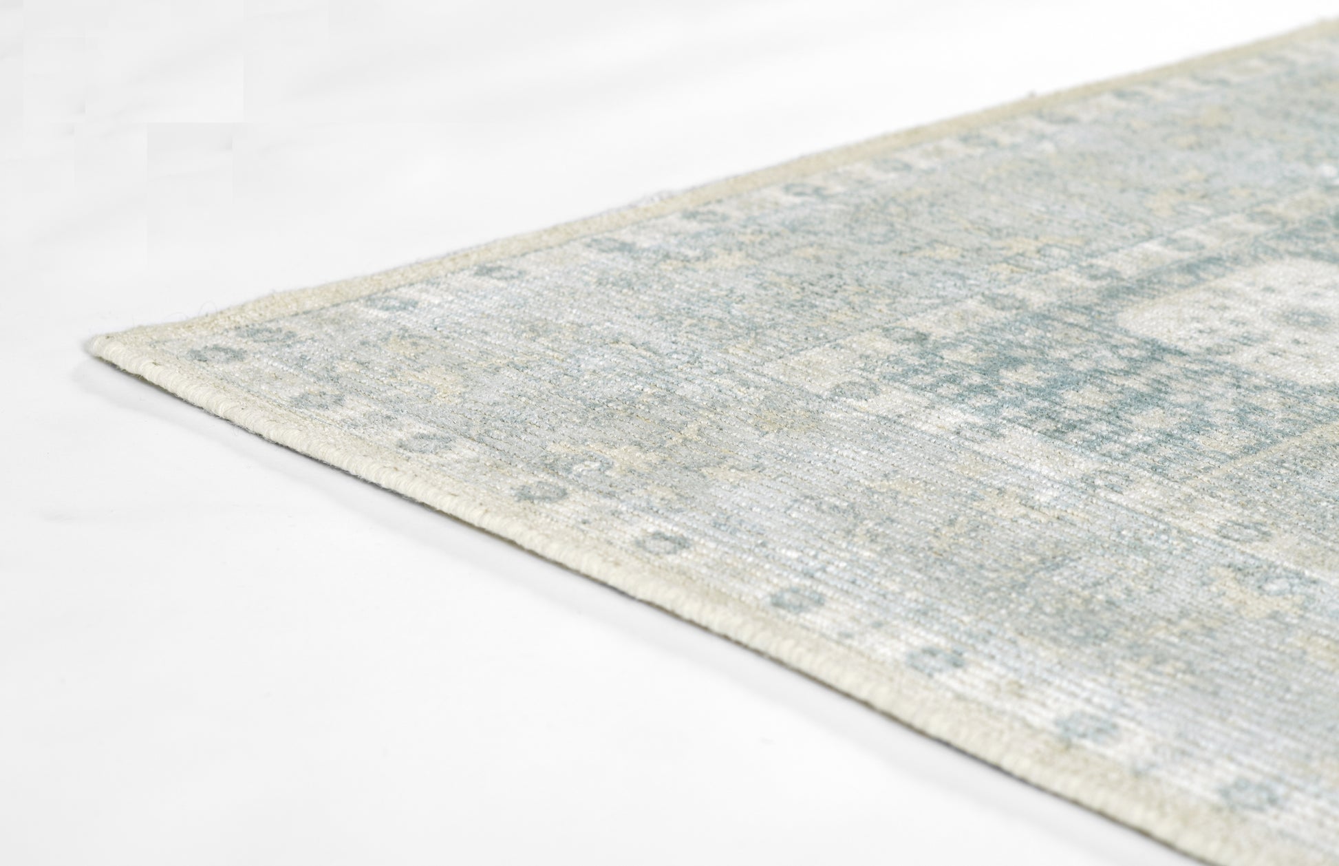 Distressed blue and ivory area rug with vintage geometric pattern, rectangular and soft for living room decor.