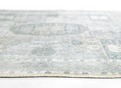 Close-up of a blue-gray woven rug with a subtle distressed pattern and light fringe edge.