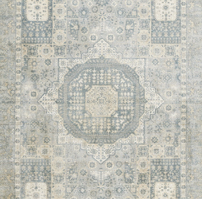 Distressed blue rug with central medallion and ivory-gray geometric motifs; vintage Persian-inspired pattern.