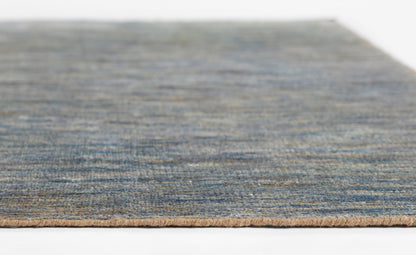 Blue flat-weave rug with subtle gradient and beige fringe edge, close-up view.