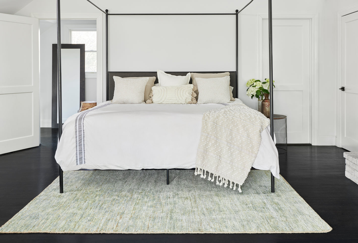 Pale green 8' x 10' area rug on dark wood floors in a modern bedroom.