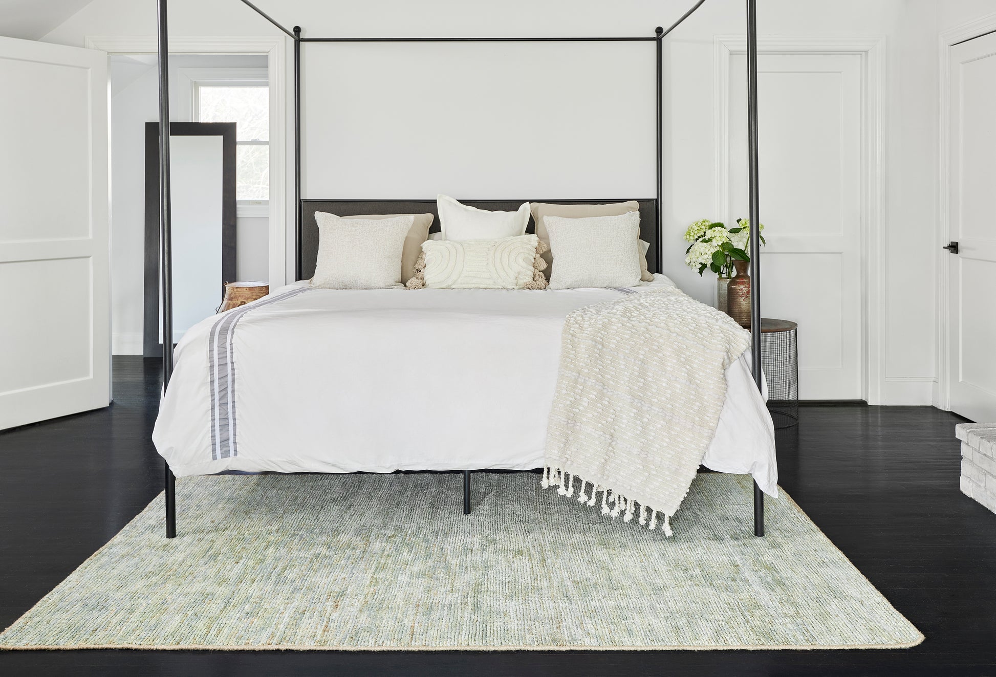 Pale green 8' x 10' area rug on dark wood floors in a modern bedroom.