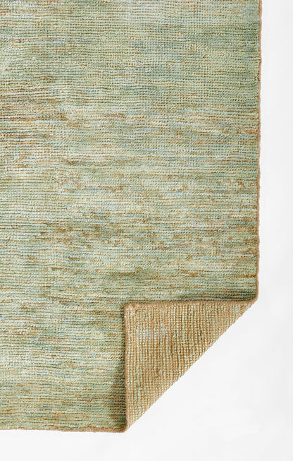 Green-blue woven rug with subtle texture; folded corner reveals tan underside.