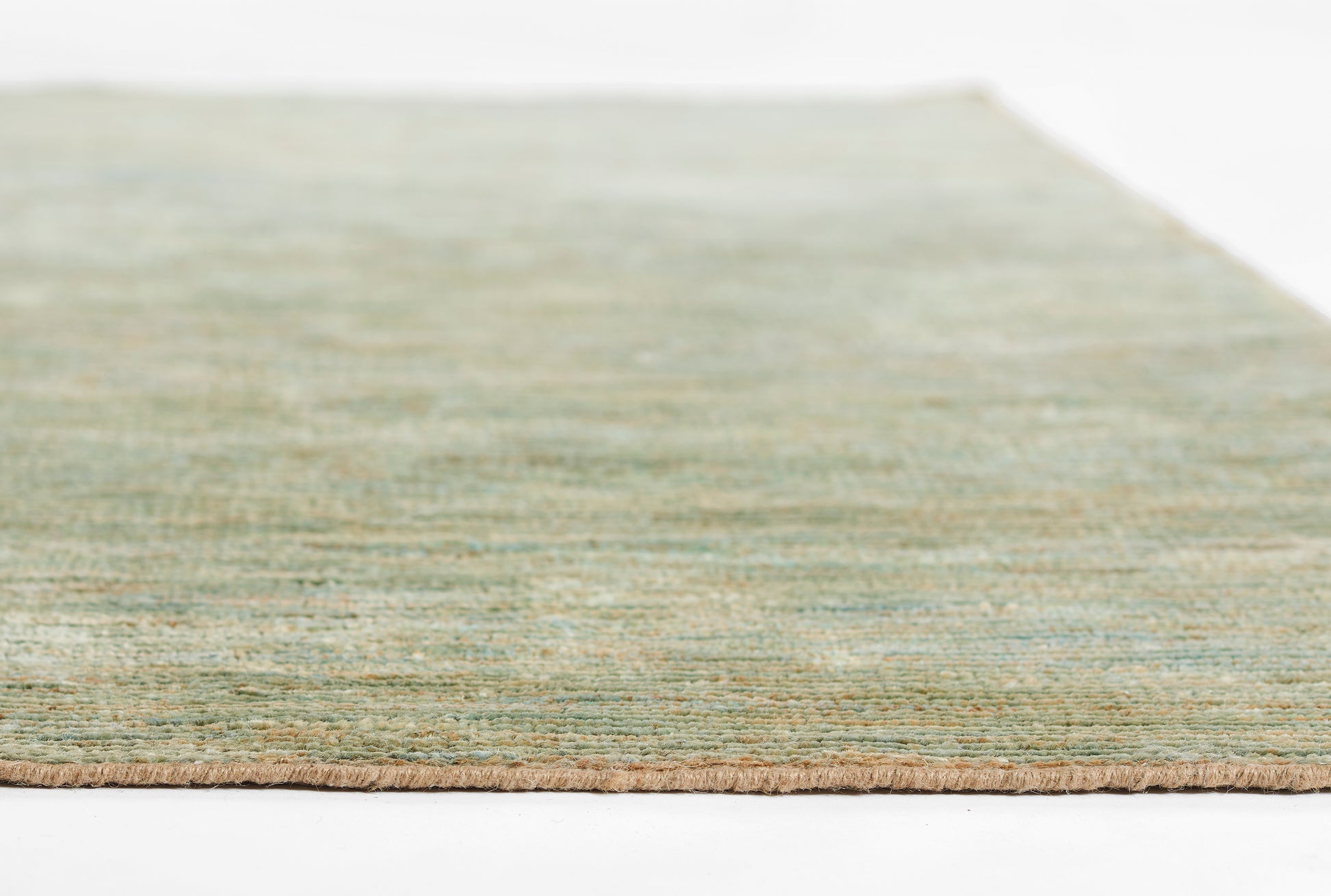 Green flat-weave rug with beige fringe edge; soft woven texture, rectangular & casual contemporary decor.