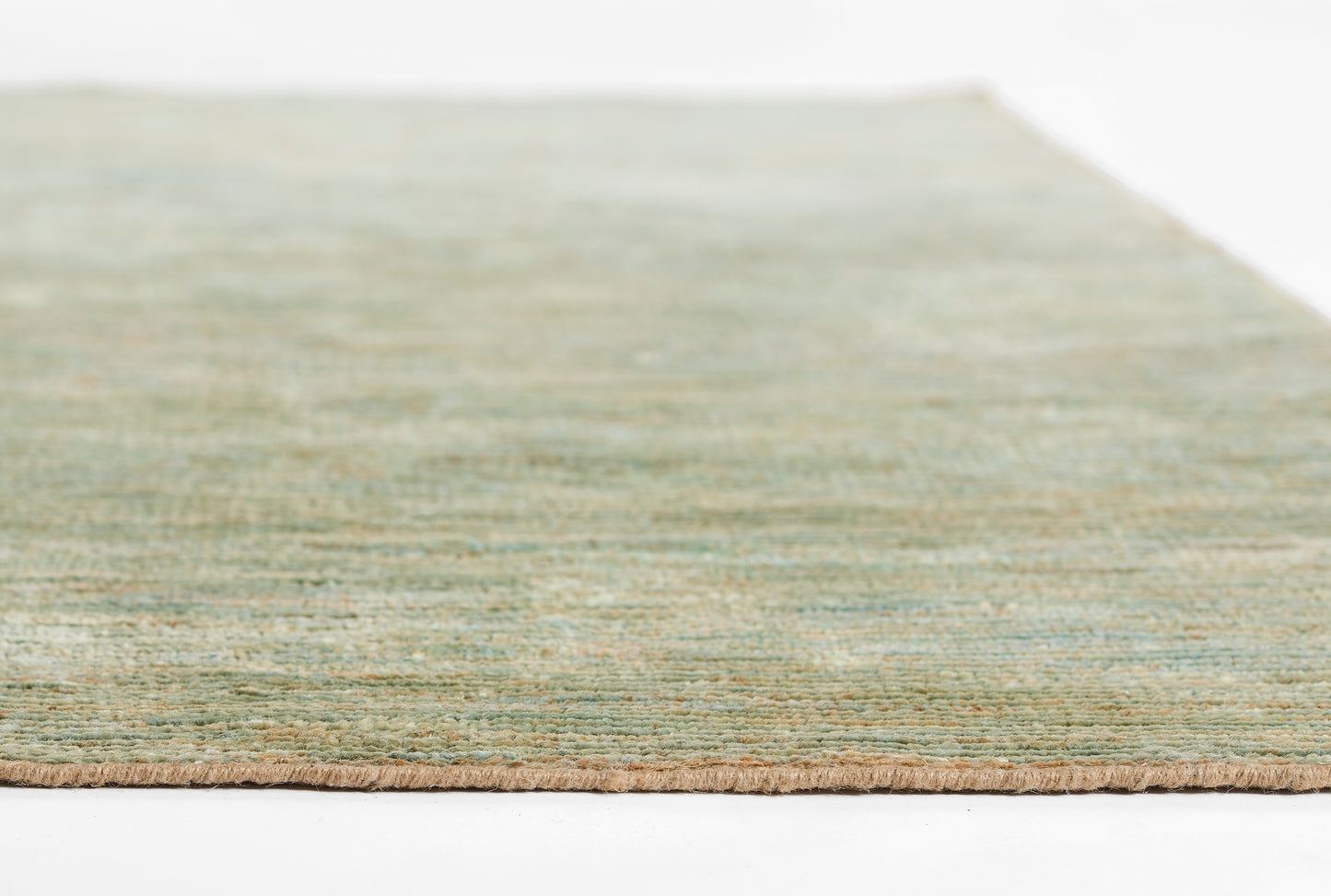 Green-toned flat-weave rug with beige fringe along edge; low-pile, contemporary decor.
